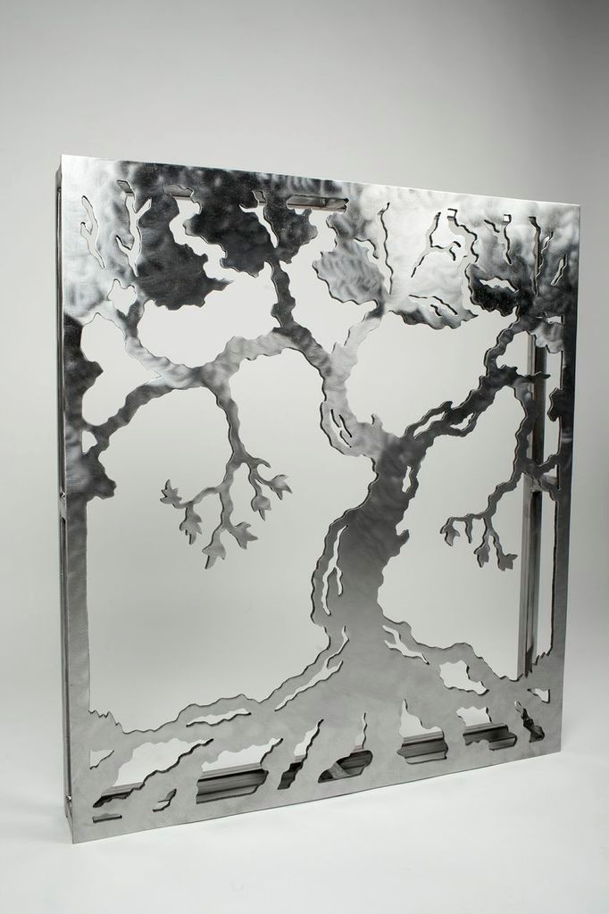 Decorative metal wall art featuring an intricately cut tree design with prominent branches and roots.