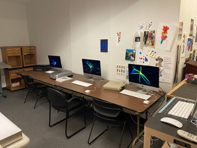 design lab with macs and scanners, drawings taped to the walls as decorations