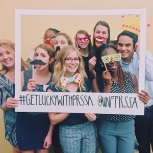 students posing with a sign with the hashtag get lucky with prssa