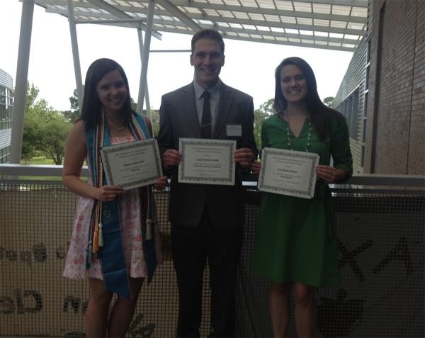 Three students holding their scholarship award certificates.