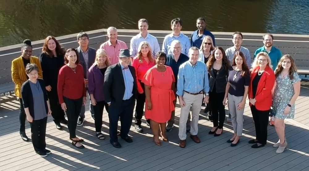 Faculty members have their 2023 photo taken on a dock at UNF.