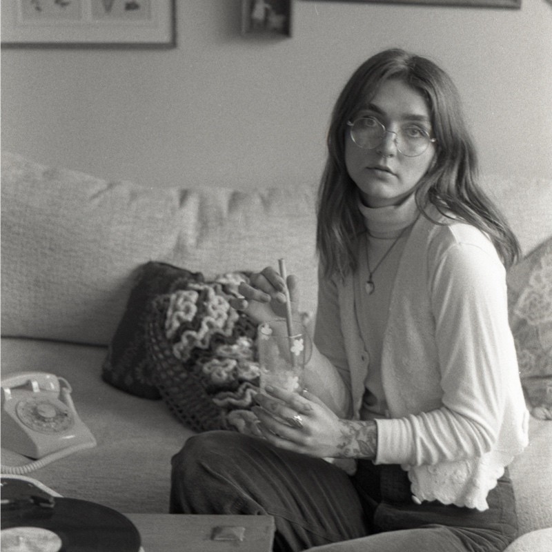 Aimee Tober seated on a couch.
