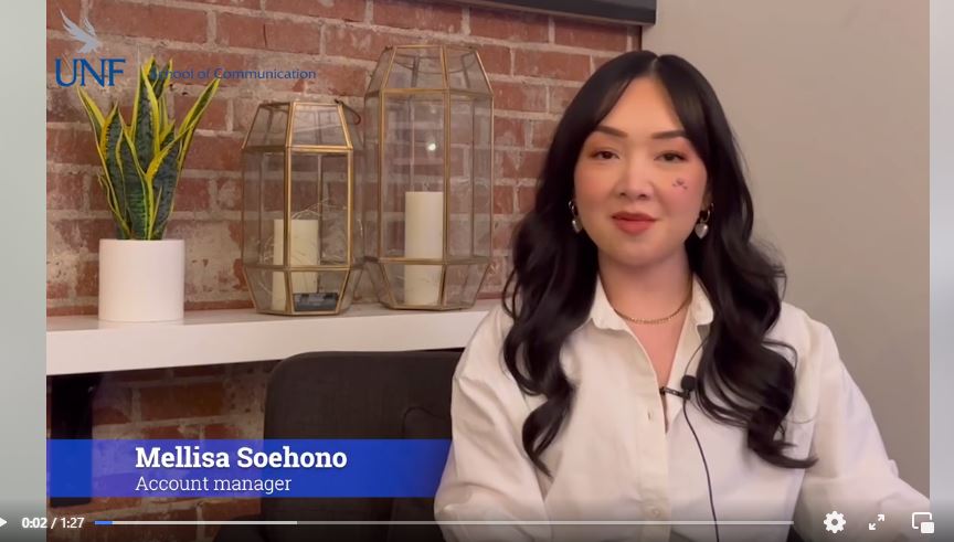 Melissa Soehono seated near a brick wall. 