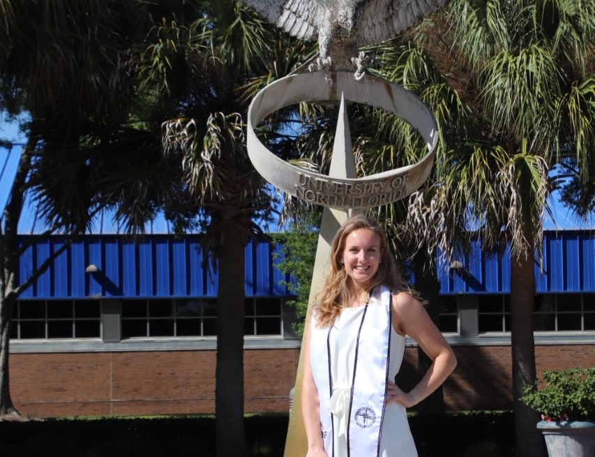 Heather Prasse stands by one of the sculptures on UNF campus. 