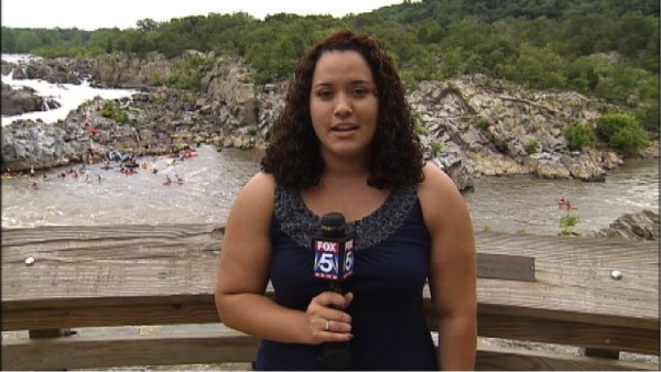 Anneliese Delgado holding a microphone outside by water.