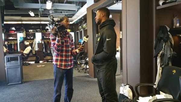 Marcel Robinson interviews a Jacksonville Jaguars in the locker room.