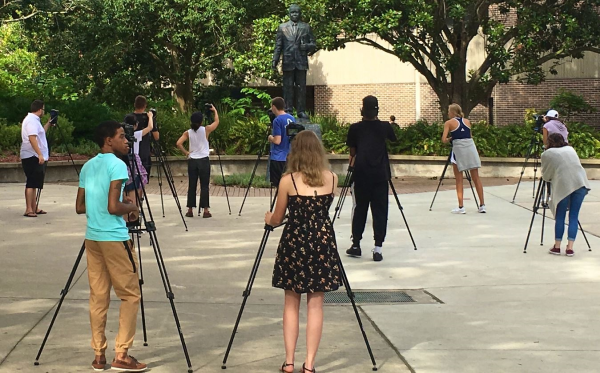 Students produce stories outside on campus.