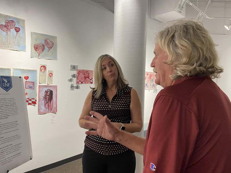 A UNF English faculty member and graduate student discuss research at a department academic event
