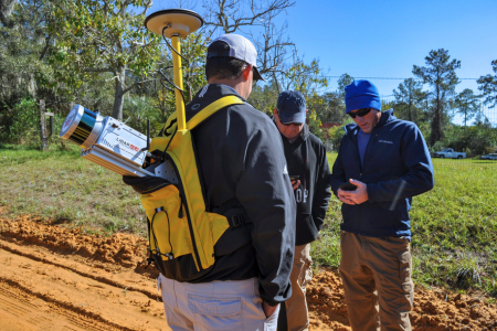 Students using GPS surveying equipment in field