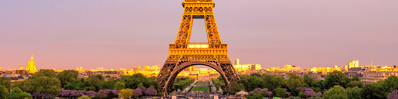 base of the eiffel tower during sunset with a pink sky background