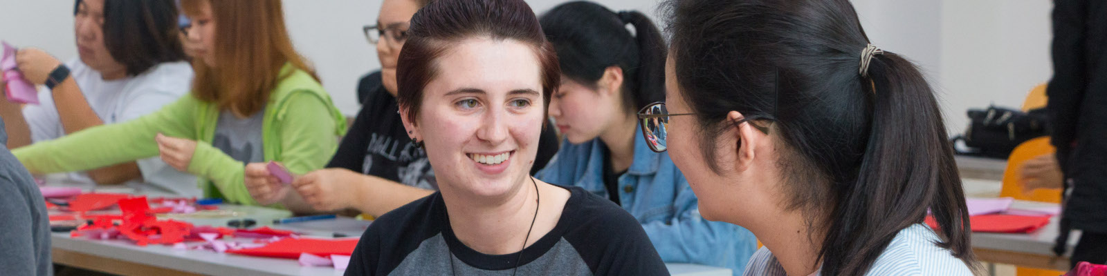 Students of different cultures sitting across from each other and talking