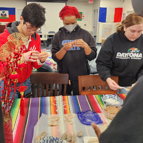 Three students in the Language and Culture Lab making dumplings