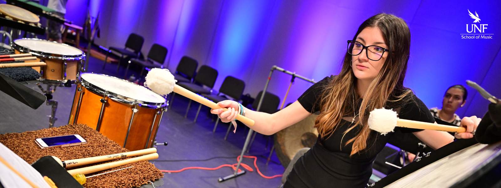 Young woman playing bass drum.