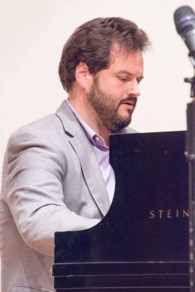 Man with beard playing piano.