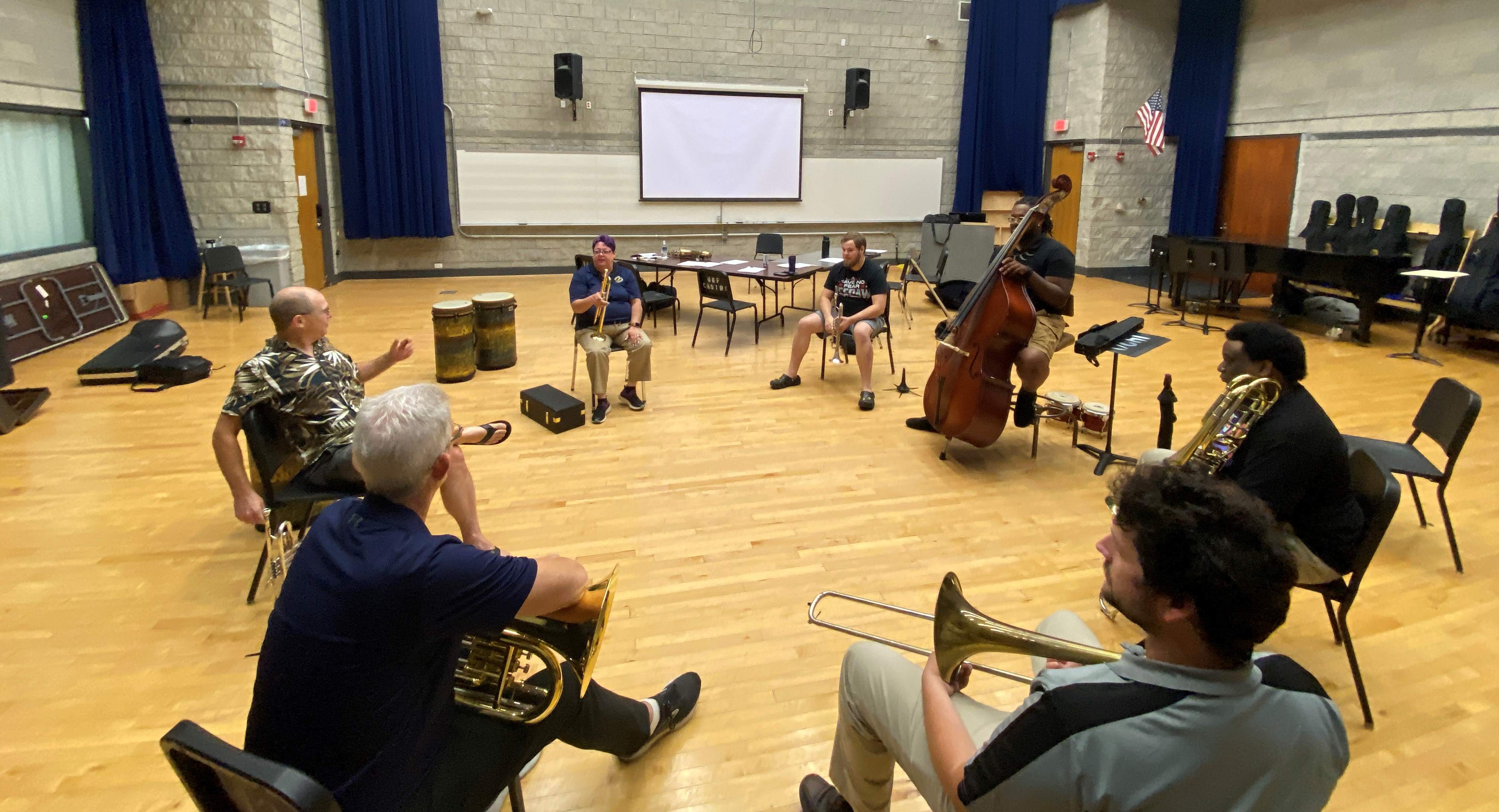 Students sitting in a circle holding instruments