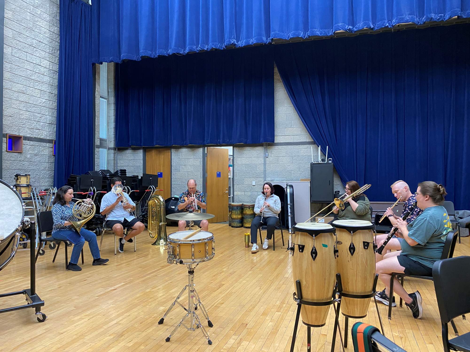 Students sitting in a circle and playing various instruments 