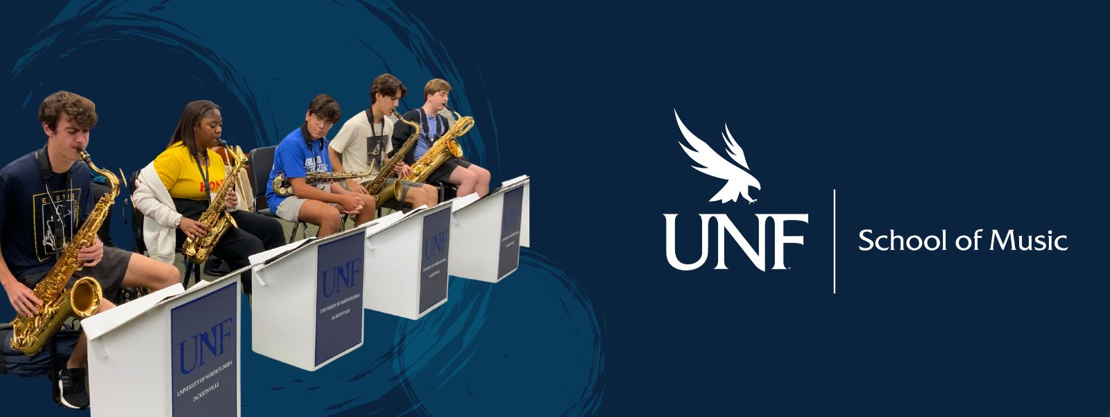 Students sitting down and playing saxophone.