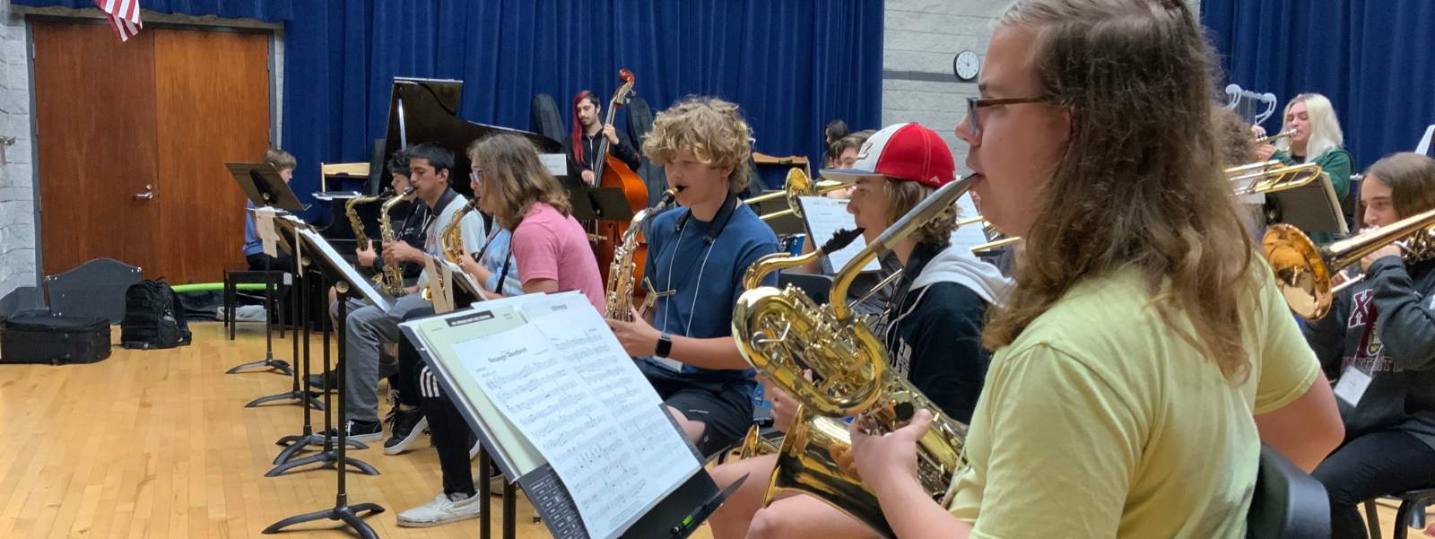 Students playing brass instruments in orchestra.