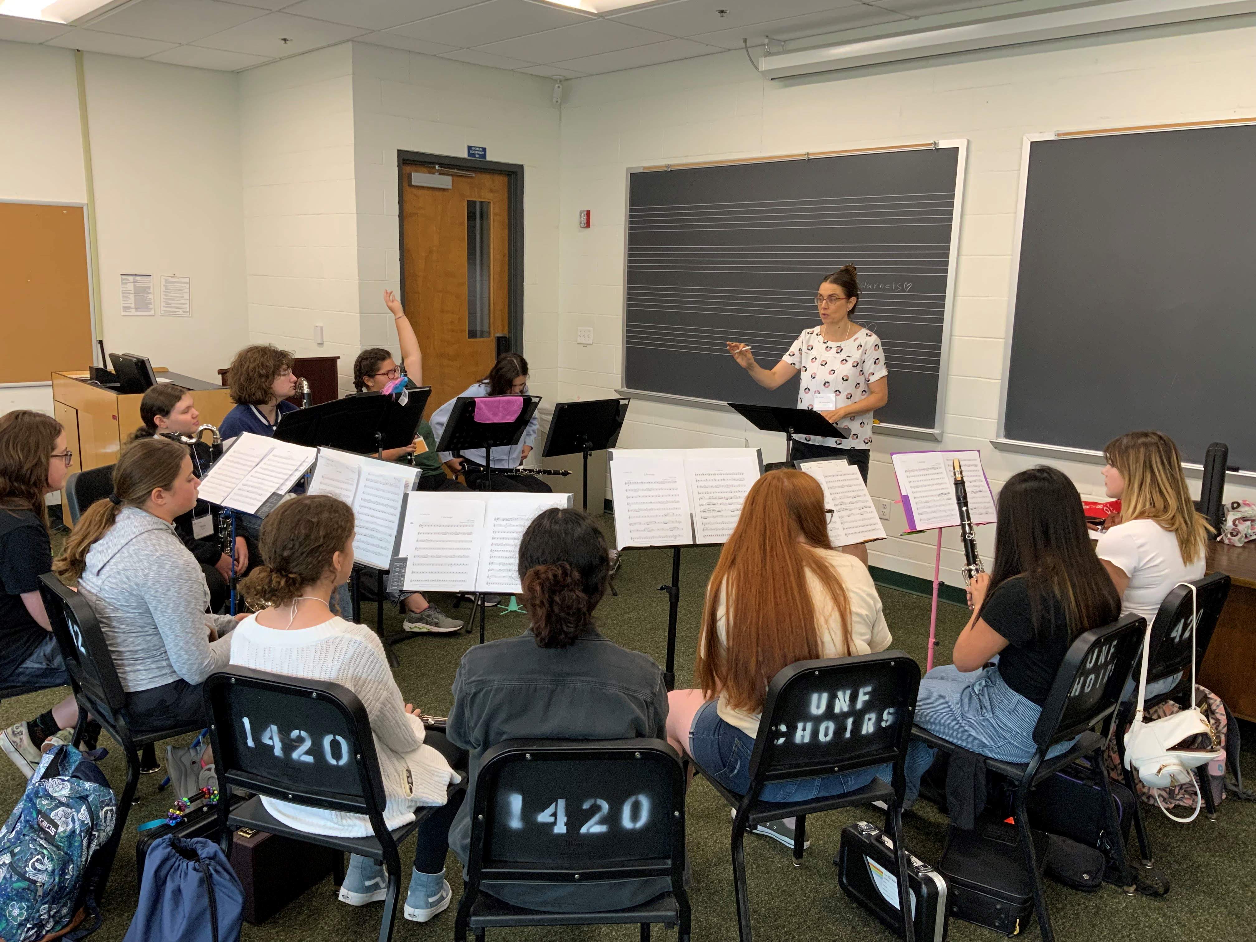 Students sitting in semicircle playing clarinets.