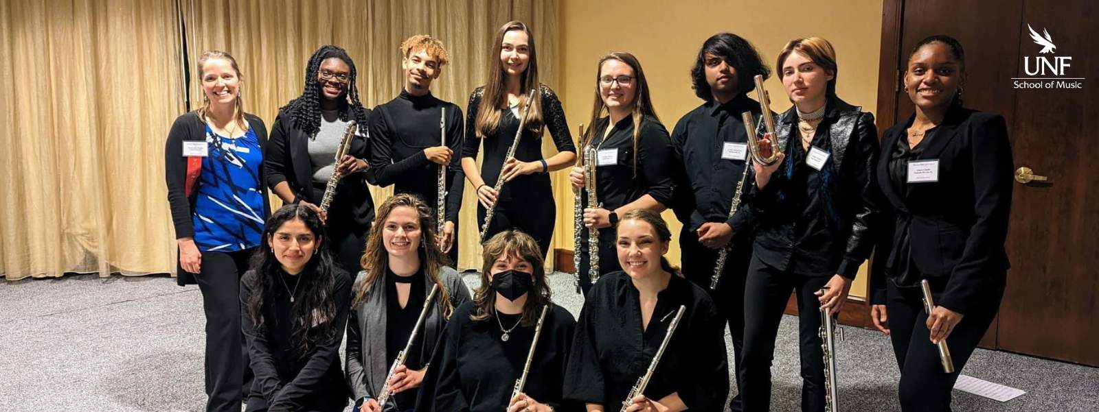 Students holding flutes and smiling.