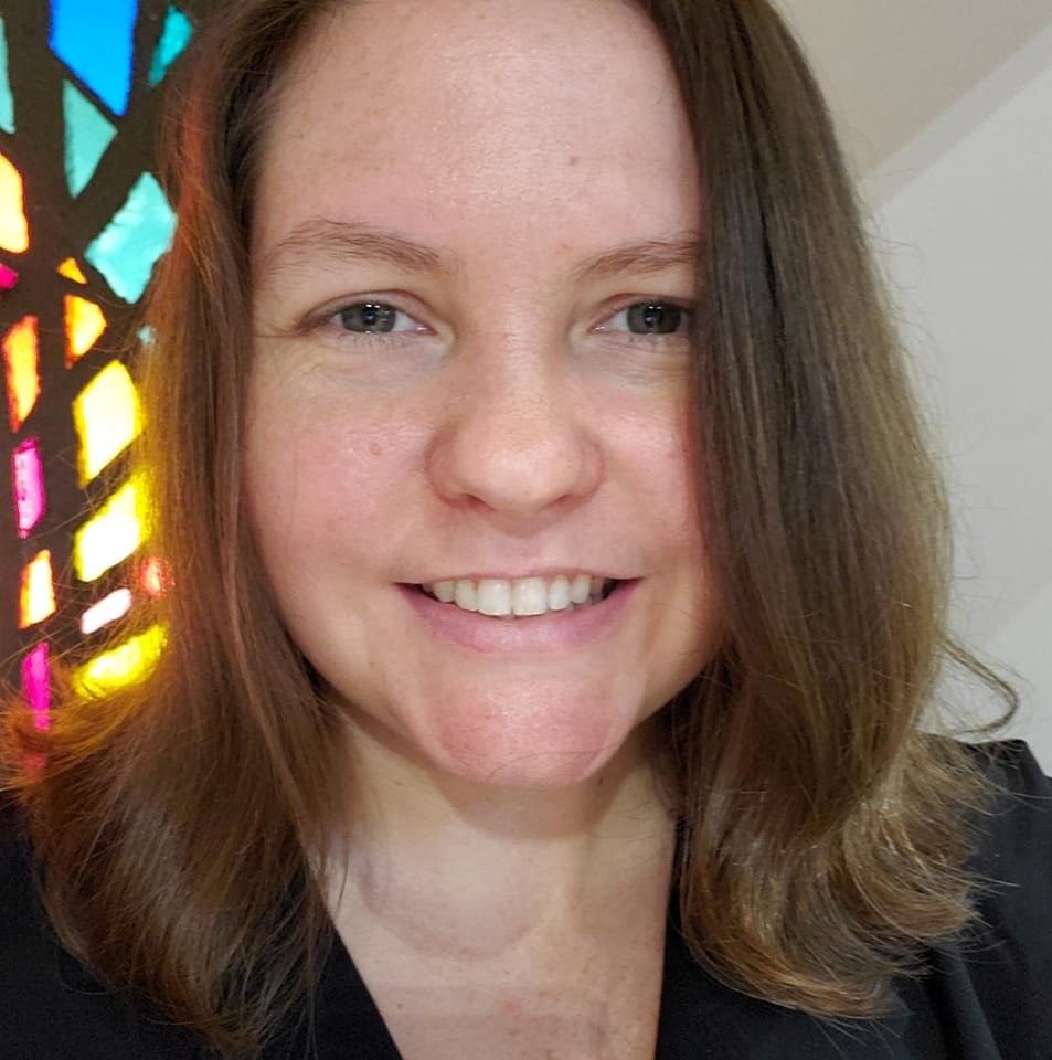 Woman with mid-length, light brown hair smiling.