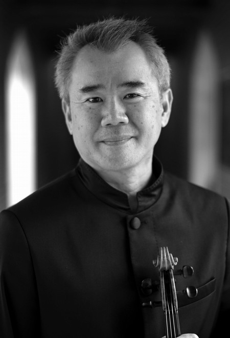 Middle-aged Asian man wearing all black suit and holding violin. He has grey hair and is smiling.