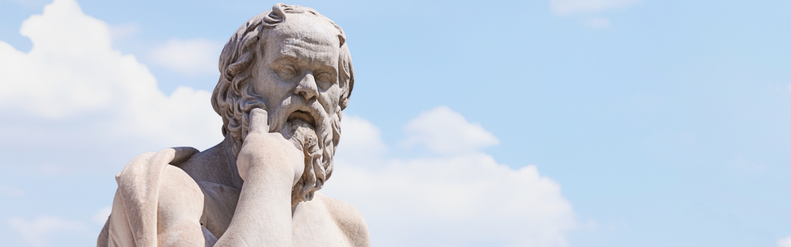 Socrates stone statue with clouds in the background