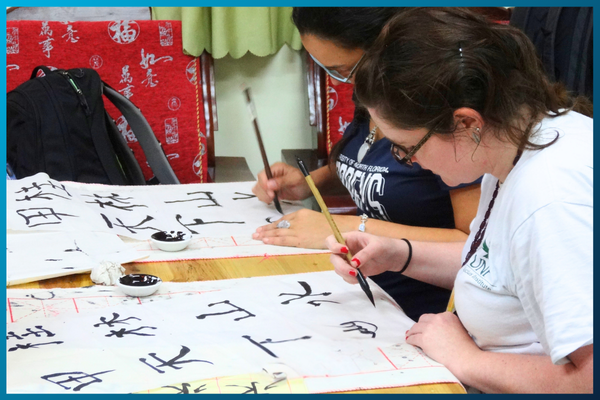 Two students practicing chinese writing