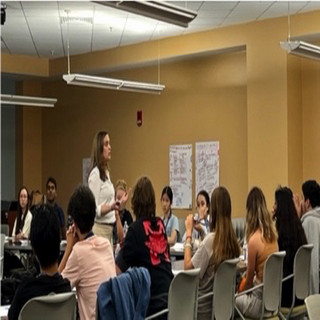 Students sitting surrounding a presenter
