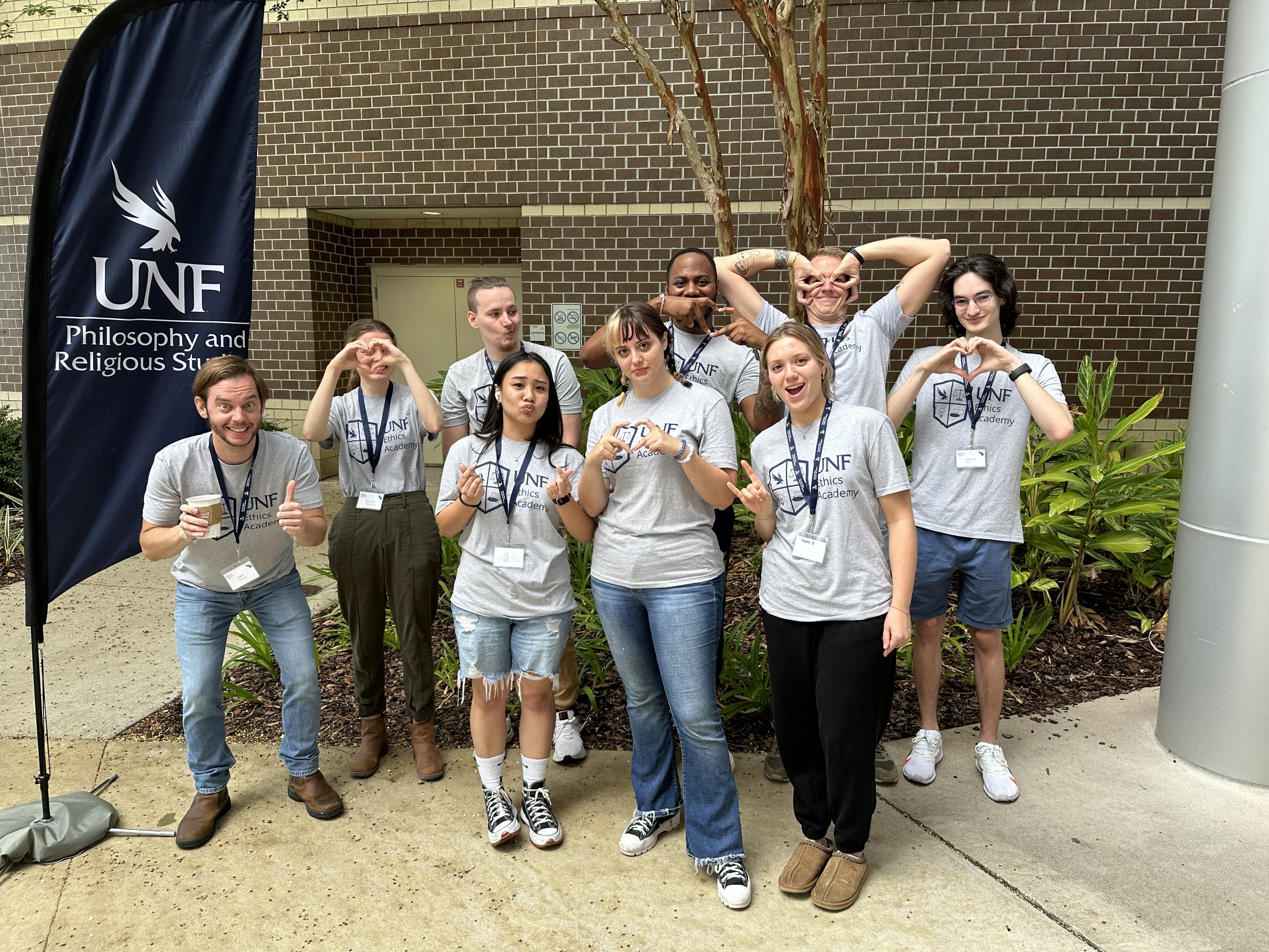 9 UNF students pose in front of brick building