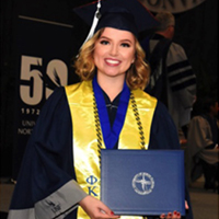 Reagan Strout at graduation holding degree