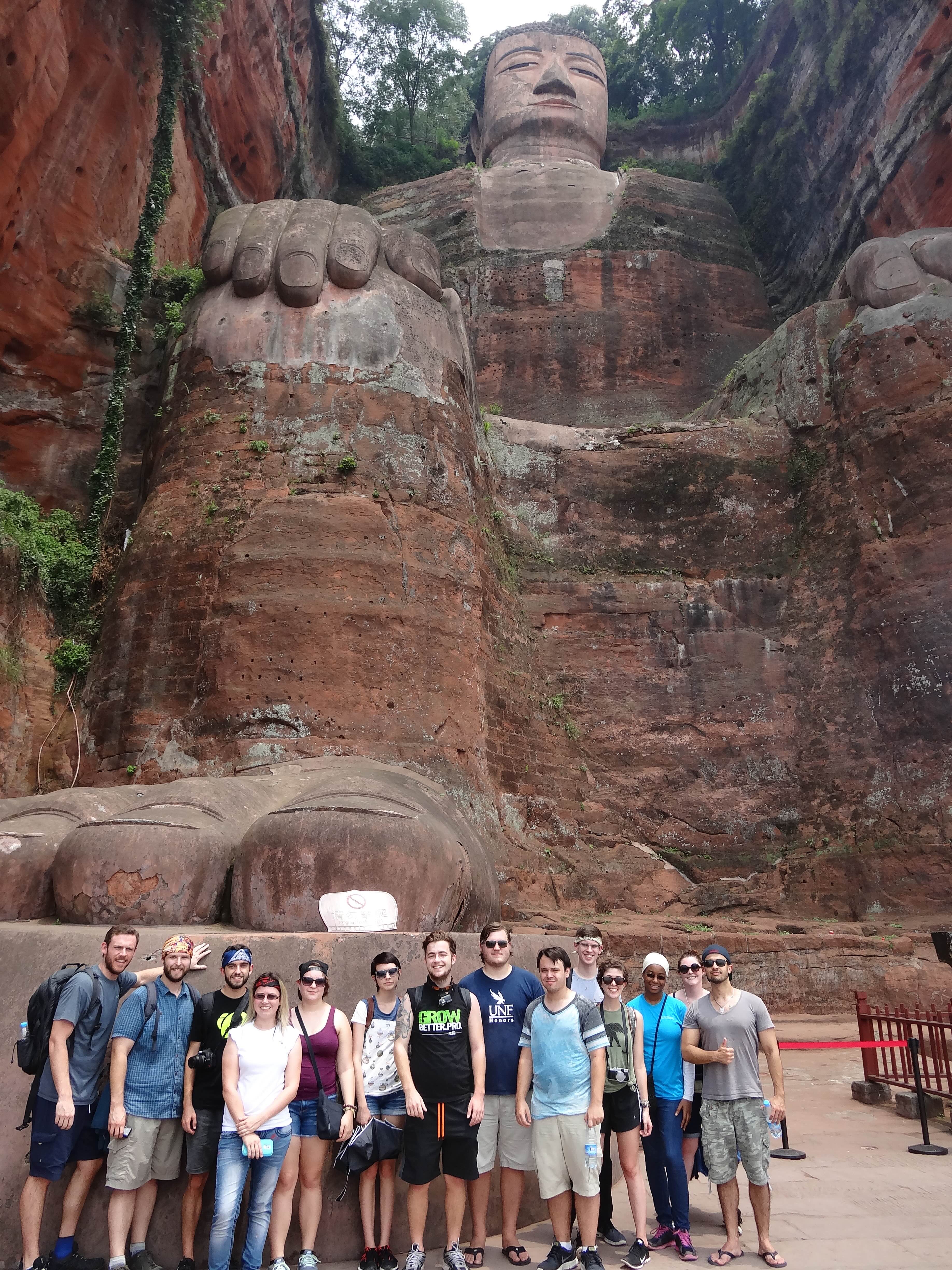 Group photo of study abroad students at the foot of the LeShan Buddha in China