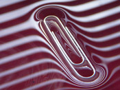 a paperclip in red shiny liquid