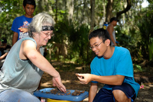 student and professor at archaeological dig