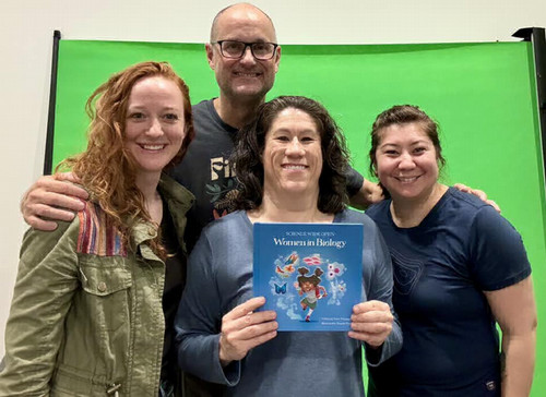 Stultz with Atomic Hands Team holding textbook