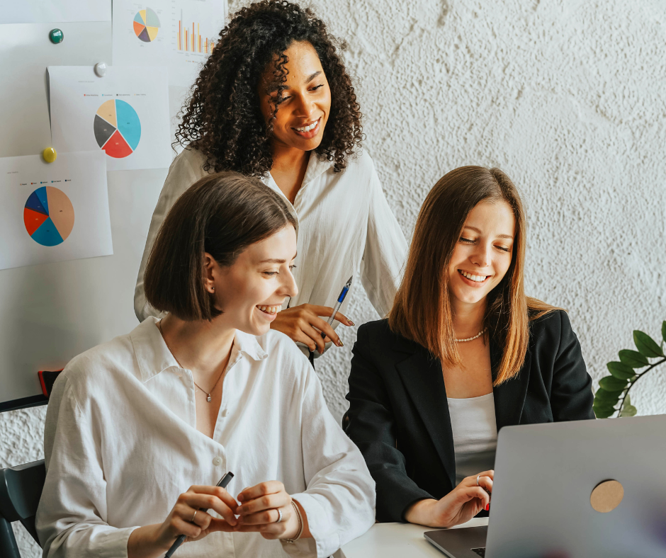 Three women working and smiling in a modern office