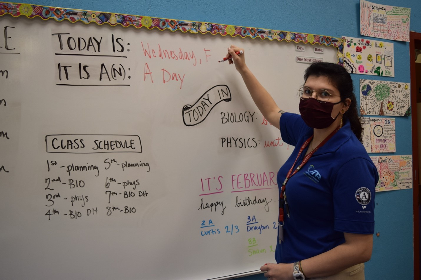Bella Kitzis writing on a board in a classroom setting
