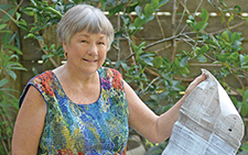 Lynne Raiser standing outside holding paper