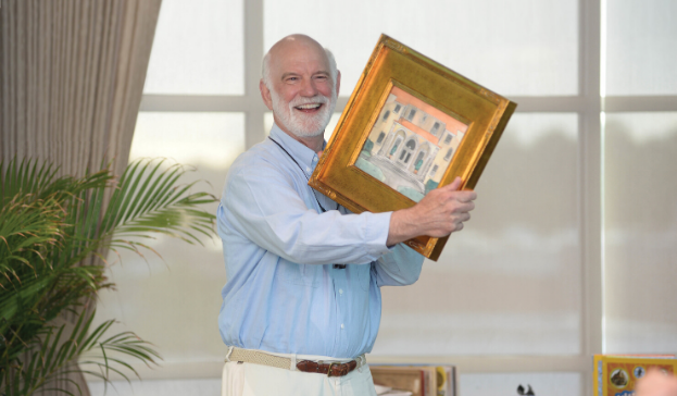 Gilchrist Berg holding a framed piece of art