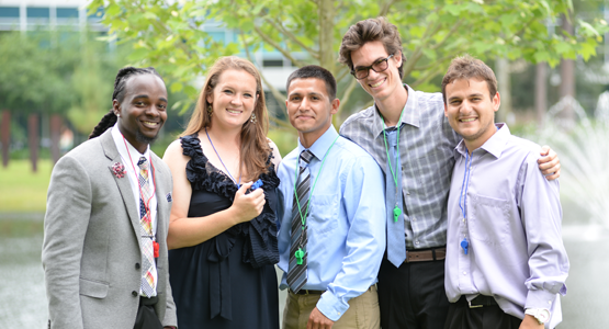 A group of students gathered in front of a water fountain by the COEHS