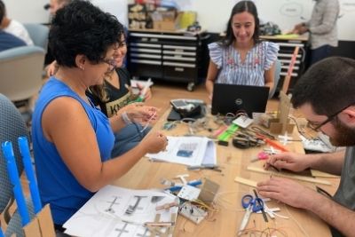 Group of adults at a classroom table working on a project together