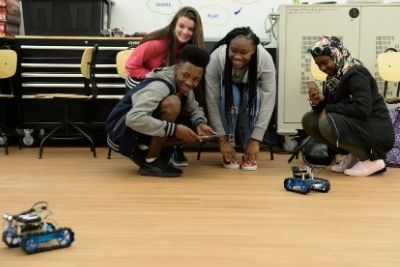 Group of college students playing with remote cars in the Step Lab