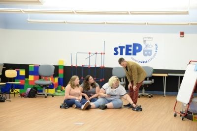 Adults in the Step Lab playing with remote control cars