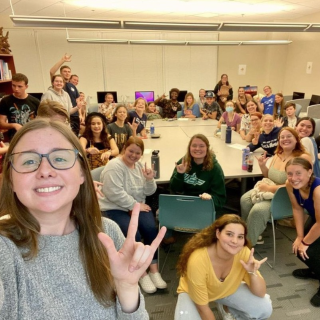 Students smiling and signing during a UNF Signing Osprey club meeting