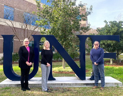 A photograph of Tara and Debbie in front of the UNF sign