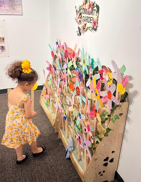 A preschooler looking at flowers