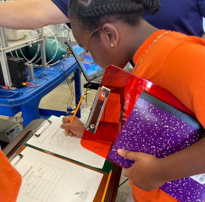 Tiger Academy student taking notes at a lab