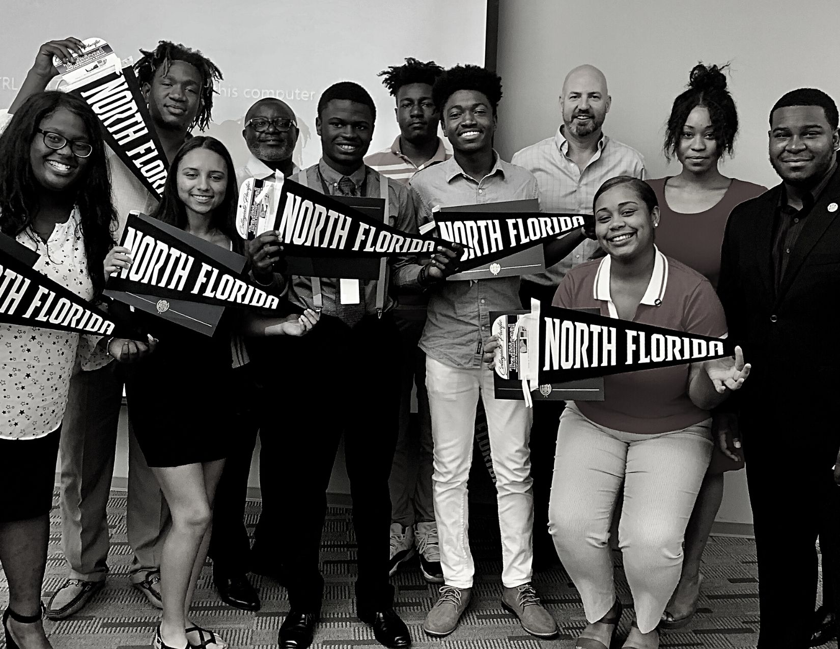 young people holding unf flags and smiling