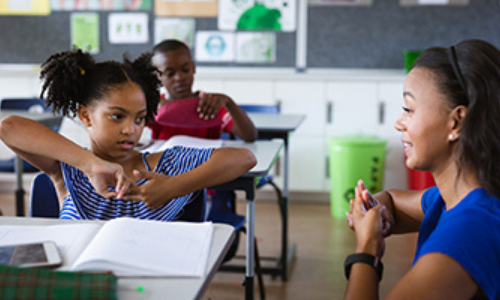 teacher and student in classroom having conversation using American Sign Language