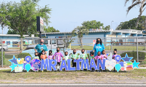 Students with a big yard sign that reads Mr. Altman